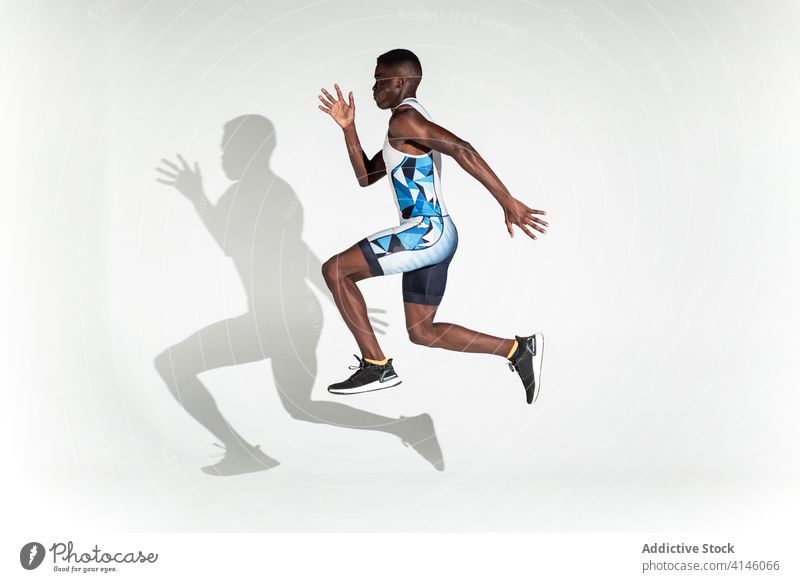 Laufender schwarzer Sportler in lila Studio Mann Läufer Athlet springen Geschwindigkeit Energie Sprint Bestimmen Sie Kraft selbstbewusst aktiv physisch