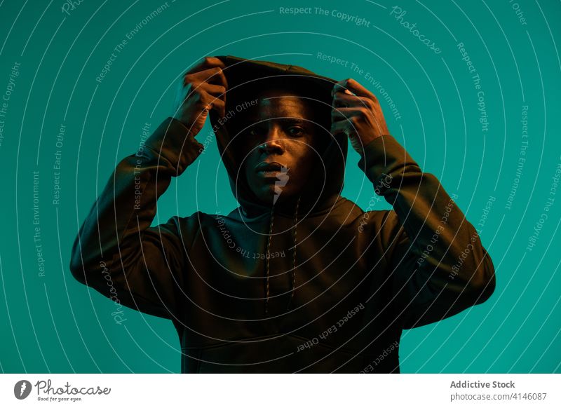 Junger ethnischer Mann mit Kapuzenpulli ernst jung selbstbewusst modern Porträt angezogen Afroamerikaner männlich Menschliches Gesicht Individualität schwarz