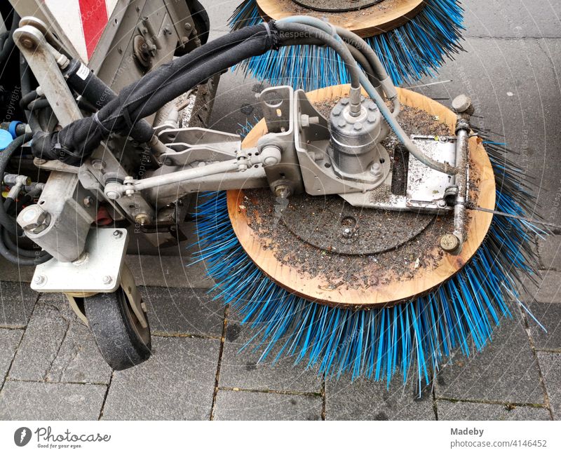 Kehrmaschine mit rotierenden blauen Borsten auf einem Gehweg in Offenbach am Main in Hessen Kehren Rotation Besen Reinigung Straßenreinigung Technik Sauberkeit