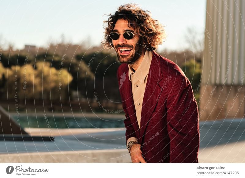 Selbstbewusster Mann, der lächelt, während er im Freien steht. Porträt Hipster urban Straße Kleidung stylisch Großstadt trendy Bekleidung Selbstvertrauen Stil
