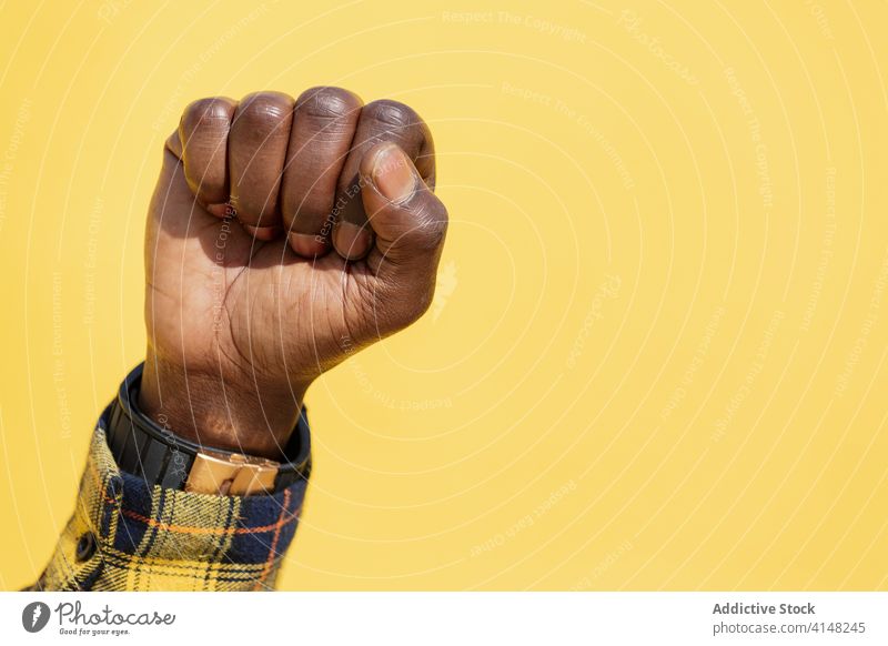 erhobene Faust eines schwarzen Mannes auf gelbem Hintergrund protestieren Person rechts kämpfen Kraft Hand Freiheit Stärke menschlich Revolution stark Arme