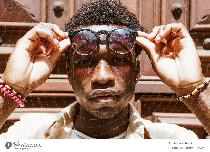 Ruhiger schwarzer Mann mit Sonnenbrille in der Stadt Stil Afro-Look trendy Großstadt Frisur urban Hipster emotionslos männlich ethnisch Afroamerikaner Barcelona