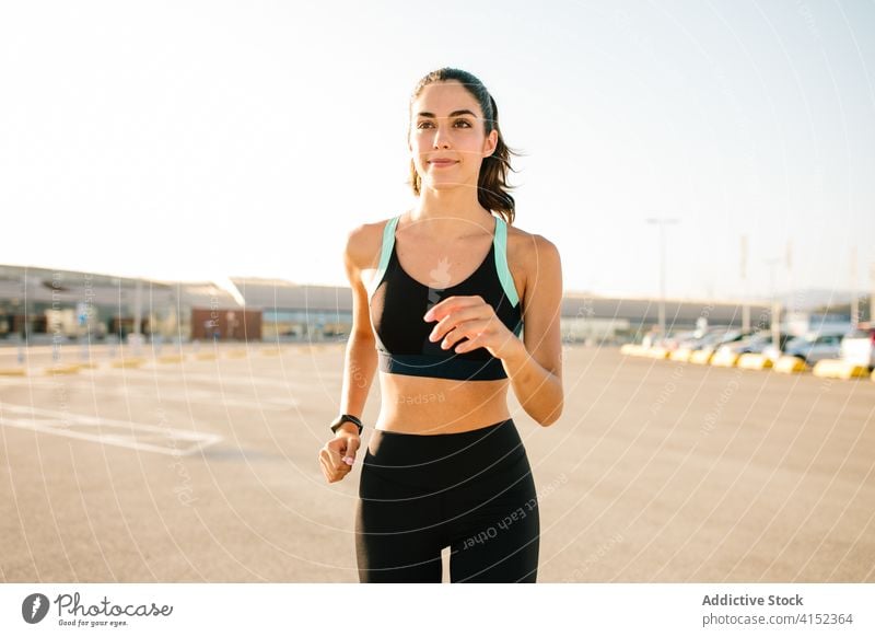 Frau läuft auf der Straße Sportlerin laufen passen schlank Läufer Training aktiv Übung jung selbstbewusst Energie sportlich Lifestyle Fitness Athlet