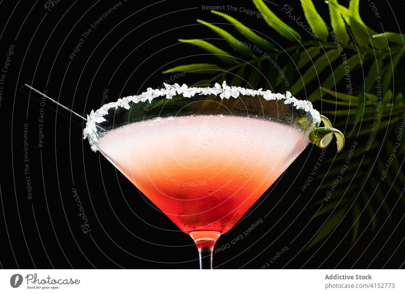 Tropischer Margarita-Cocktail mit Grenadine auf glitzerndem Tisch Feinschmecker Likör Salz Hintergrund Feier rot Geschmack gekühlt Licht vertikal Limettenzwirn