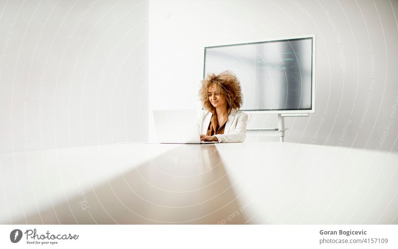 Afroamerikanische Geschäftsfrau sitzt und arbeitet am Laptop im modernen Büro Erwachsener Afrikanisch Afro-Look Amerikaner schön schwarz Business selbstbewusst
