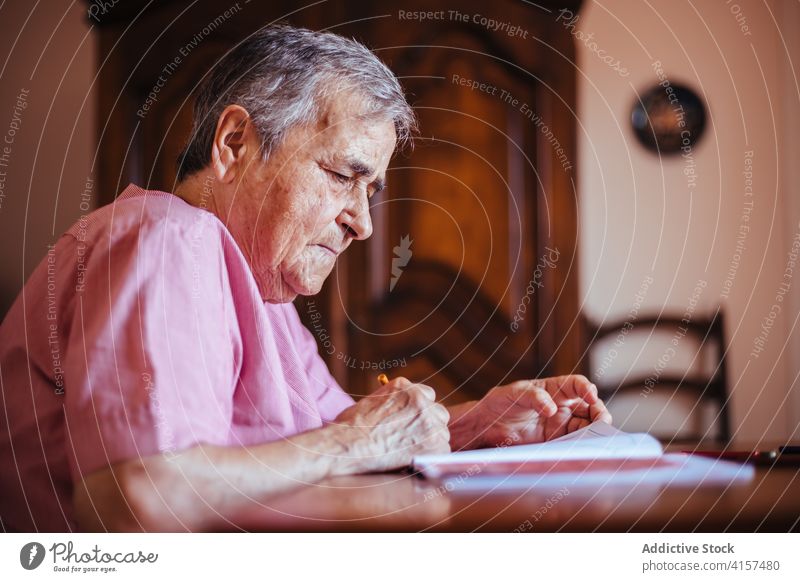 Ältere Frau malt auf einem Notizbuch Alzheimer mental Gesundheit Malerei Bleistift Notebook Ruhestand Großmutter Rentnerin Senior Demenz Haus älter