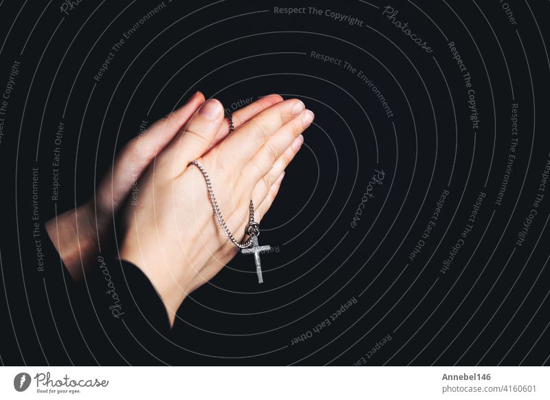 Betende Hände halten einen Rosenkranz, Closeup halten Halskette mit Kreuz, beten für Gott in der Dunkelheit, religiöse christliche Symbol Hintergrund Frau Hand