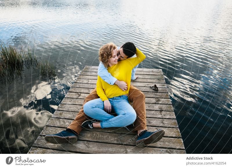 Zufriedenes Paar umarmt auf Pier im Sommer hölzern See Umarmen Liebe Angebot Partnerschaft Teich sorgenfrei Windstille Freundin sanft romantisch Zuneigung