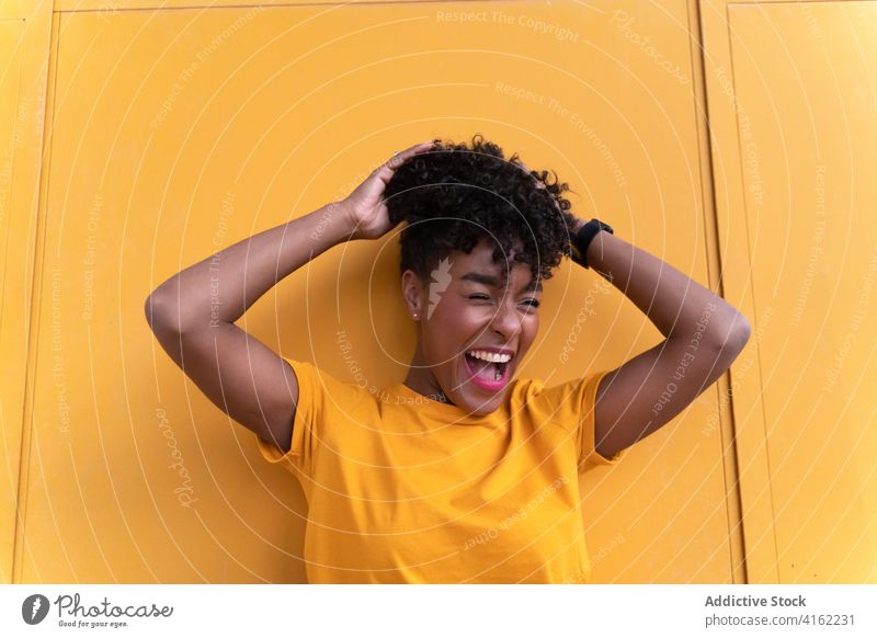 Fröhliche schwarze Frau in hellem Outfit Glück heiter farbenfroh Lächeln gelb Stil positiv selbstbewusst jung Afroamerikaner ethnisch Afro-Look lässig modern