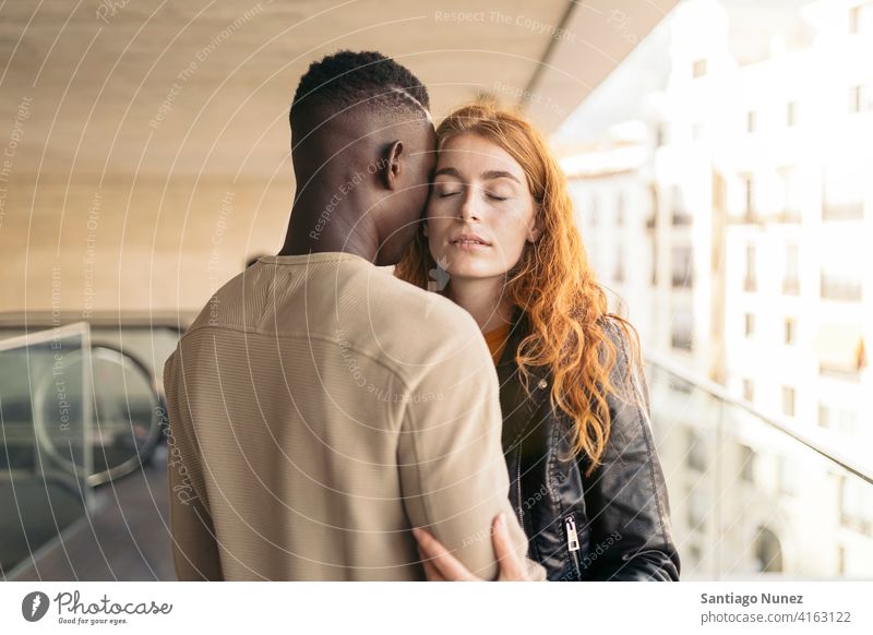 Liebendes multiethnisches Paar, das sich umarmt Augen geschlossen Porträt Vorderansicht umarmend Stehen Partnerschaft multirassisch Schwarzer Mann Kaukasier