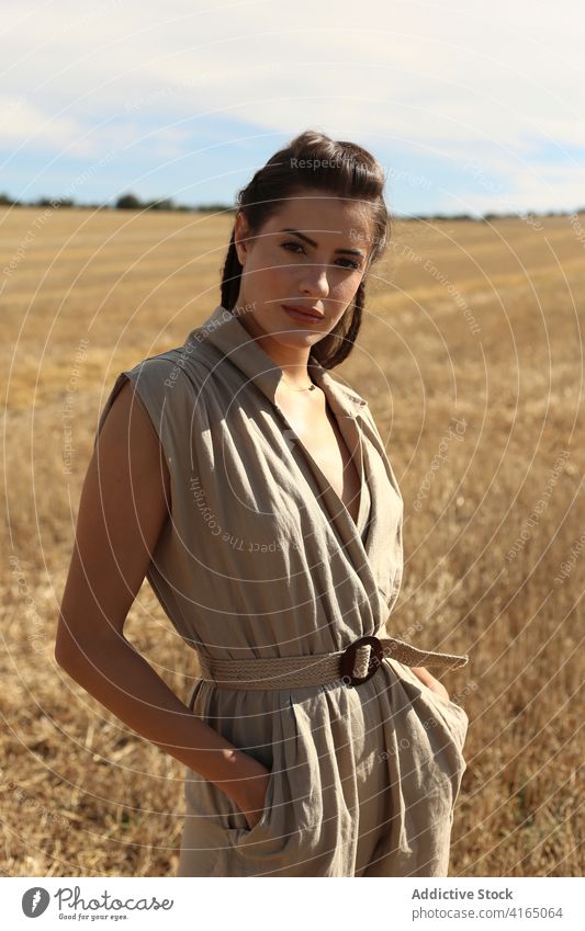 Wunderschöne Frau auf einem Feld auf dem Land stehend Spaziergang Stil traumhaft Anmut Landschaft trendy elegant schlendern Umwelt malerisch Mode attraktiv