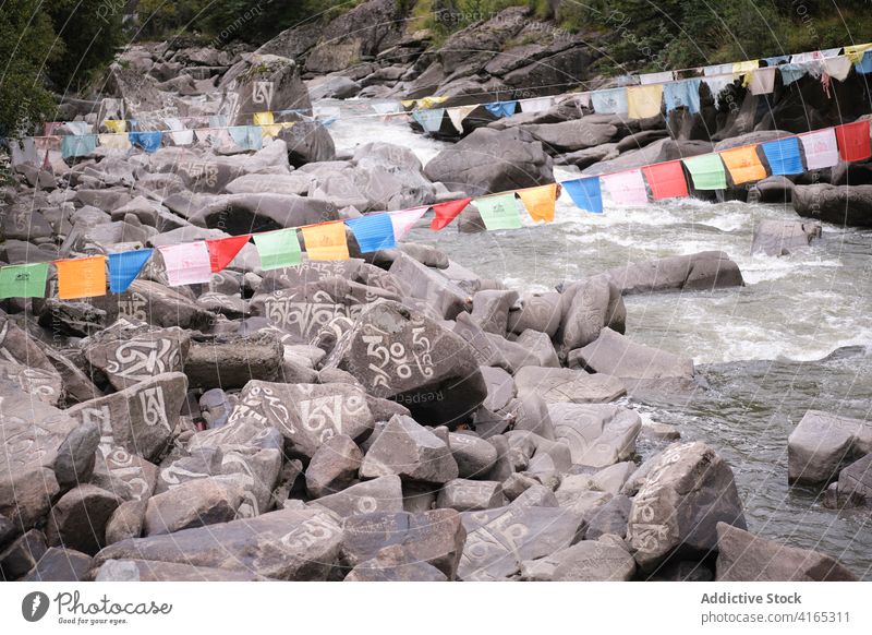 Sanskrit-Mantra auf Steinen im Fluss om mani padme hum Religion strömen fließen Landschaft Gelände Glaube Natur felsig malerisch Wasser reisen Dorf China baiyu