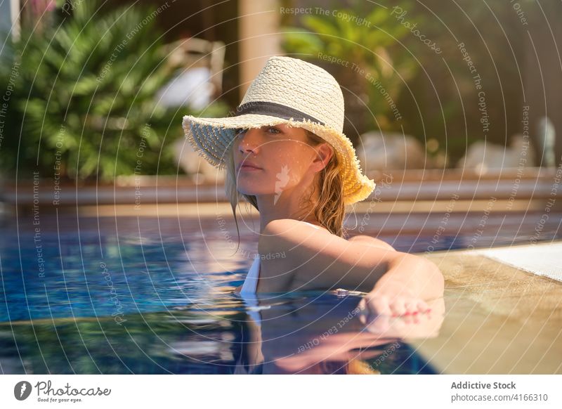 Sinnliche Frau mit Hut entspannt sich im Pool Sommer Kälte sinnlich sich[Akk] entspannen Beckenrand genießen Reflexion & Spiegelung jung Resort Urlaub Feiertag