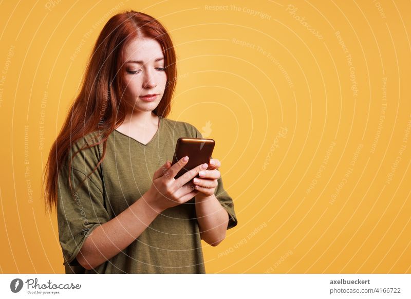 Junge Frau liest Textnachricht auf Smartphone oder Handy Nachricht lesen Texten SMS soziale Netzwerke Telefon Mädchen benutzend ernst Kaukasier lässig