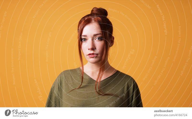 Porträt einer hübschen jungen Frau mit rotem Haar Dutt Junge Frau rothaarig Mädchen Vorhangpony Haarknoten Rotschopf Erwachsener schön ernst Gesicht Model