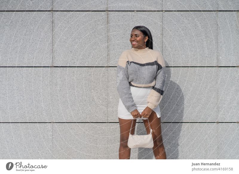 glückliche junge schwarze Frau in Rock und Pullover spektakulär Glück Ethnizität Afrikanisch Afro-Look Lächeln Freude Lachen Afroamerikaner Dame horizontal