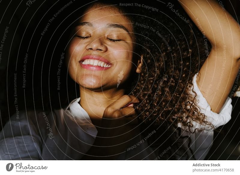 Ruhige ethnische Frau im Sonnenlicht Behaarung Afro-Look Frisur sich[Akk] entspannen ruhig Stil Windstille jung Afroamerikaner schwarz traumhaft Schatten