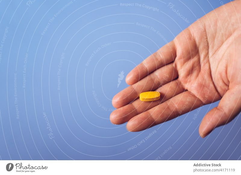 Anonyme Person zeigt gelbe Pille Tablette Hand Vitamin Gesundheitswesen medizinisch Ergänzung zeigen manifestieren Leckerbissen Medizin Medikament Therapie