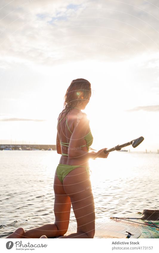 Fit Frau steht auf Paddle Board im Meerwasser Paddel Holzplatte aktiv schlank Surfer MEER Wasser Küste Strand Zusatzplatine Paddelbrett Lifestyle Sommer Ufer