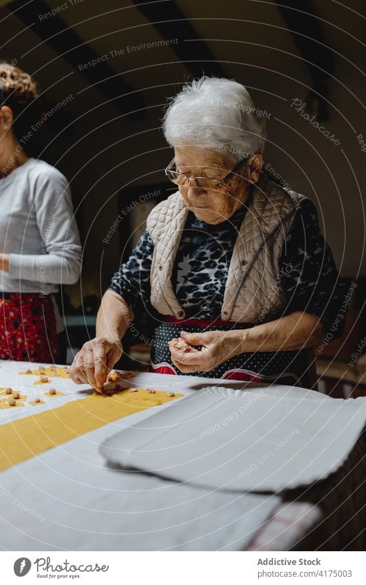 Ältere Frau kocht Tortellini in der Küche zu Hause Koch Tradition Italienische Küche selbstgemacht Teigwaren Knödel Zeug Senior gealtert Lebensmittel