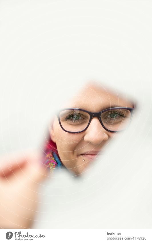 Frau schaut freundlich durch eine Spiegelscherbe in die Kamera feminin Junge Frau Mensch Erwachsene 18-30 Jahre Porträt Gesicht Kopf Spiegelung Brille Blick