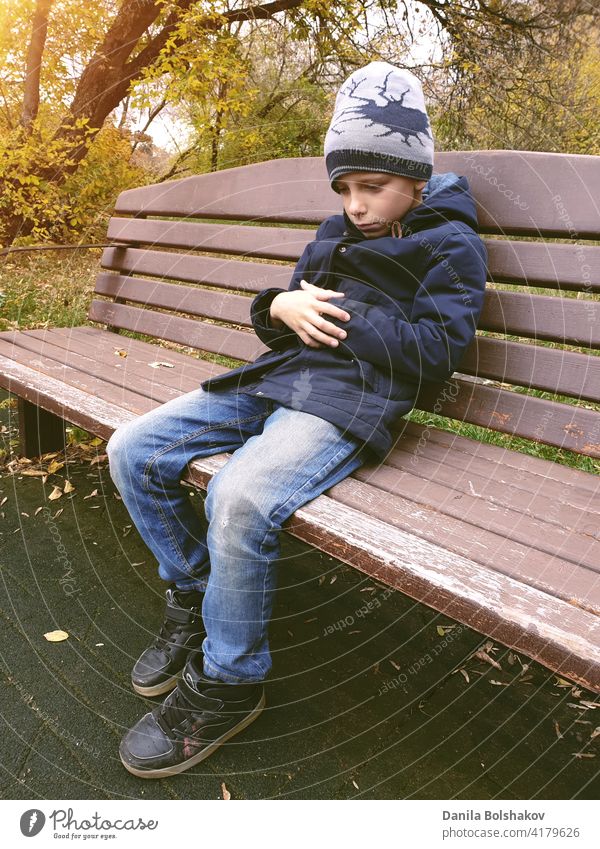 trauriger Junge sitzt auf Bank allein im Freien hoffnungslos Erinnern an nachdenklich negativ Fehler beunruhigt verzagt Jugendlicher gutaussehend Bildung