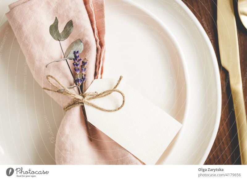 Details zur Tischgestaltung auf weißen Tellern. Tabelleneinstellung Detailaufnahme Serviette rosa Leinen geblümt Tag blanko Lavendel abschließen golden Besteck