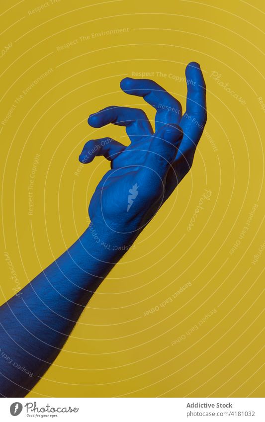 Die blaue Hand des Mannes hält etwas Unsichtbares dunkelblau vorbei gelb Hintergrund offen Handfläche Pop-Art zeigend Konzepte vereinzelt copyspace männlich