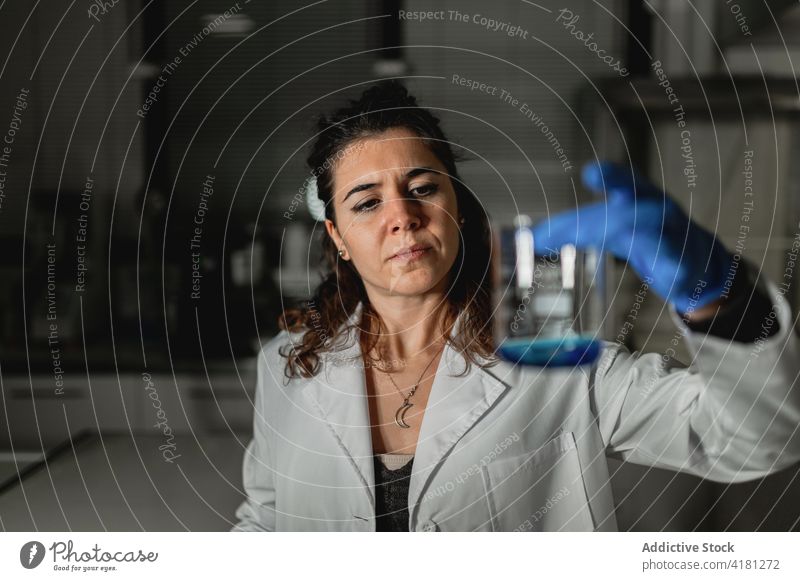 Fokussierter Wissenschaftler, der eine chemische Lösung im Labor untersucht steril liquide forschen Chemie untersuchen Glas Pharma Medizin Experiment Prüfung
