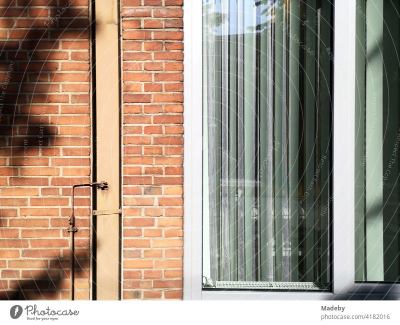 Backsteinfassade mit großem Fenster und Lamellen als Sonnenschutz bei Sonnenschein in Bielefeld im Teutoburger Wald in Ostwestfalen-Lippe Fassade Klinker