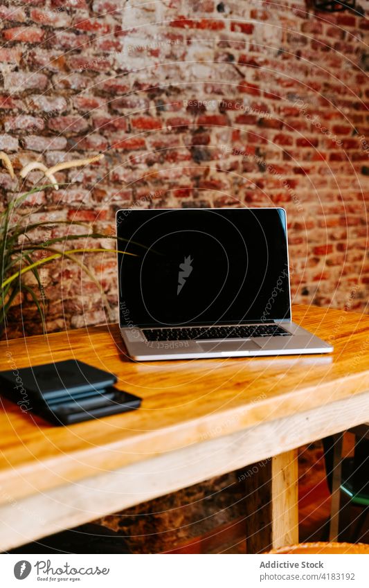 Laptop auf dem Tresen eines Cafés Abfertigungsschalter Kaffeehaus Netbook Gerät Loft Stil Innenbereich hölzern Tisch modern freiberuflich Arbeitsplatz