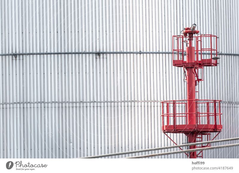 Tanklager mit roter Treppe im Hafen Hafenanlage Energiewirtschaft Lager Gasometer Brennstoff Industrieanlage Öltank Gastank Treppengeländer Fassade Stahlwand
