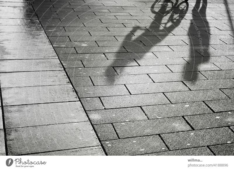 Dialog einer Begegnung Personen Schatten Menschen Gespräch Treffen Fußgänger Fahrradfahrer Kommunikation schwatzen Platz Gehwegplatten Kommunizieren Fußweg