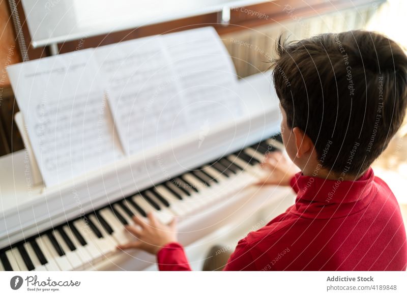 Junge spielt zu Hause Klavier Kind spielen Probe Gesang Musik Musiker Hinweis Melodie heimwärts lernen sitzen Talent Instrument Fähigkeit üben Klang Hobby
