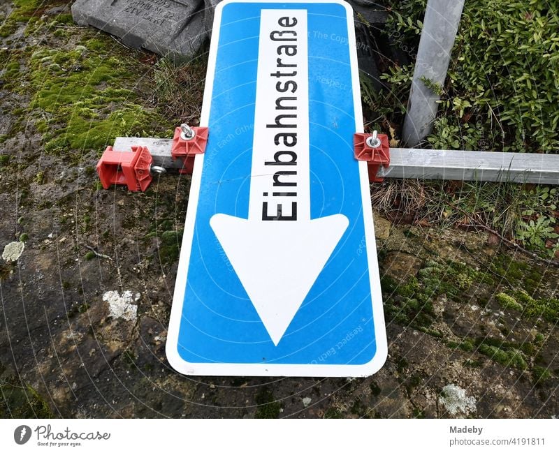 Blaues Verkehrszeichen mit der Aufschrift Einbahnstraße auf dem Boden liegend an einer Baustelle in Oerlinghausen bei Bielefeld am Hermannsweg im Teutoburger Wald in Ostwestfalen-Lippe