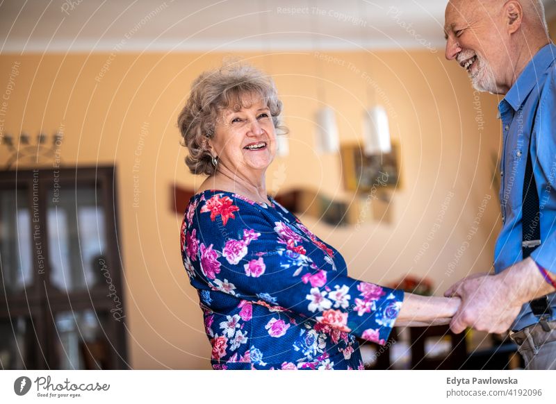 Glückliches Seniorenpaar tanzt zusammen zu Hause echte Menschen offen Frau reif männlich Mann Paar Zusammensein Liebe Bonden Kaukasier älter heimwärts alt