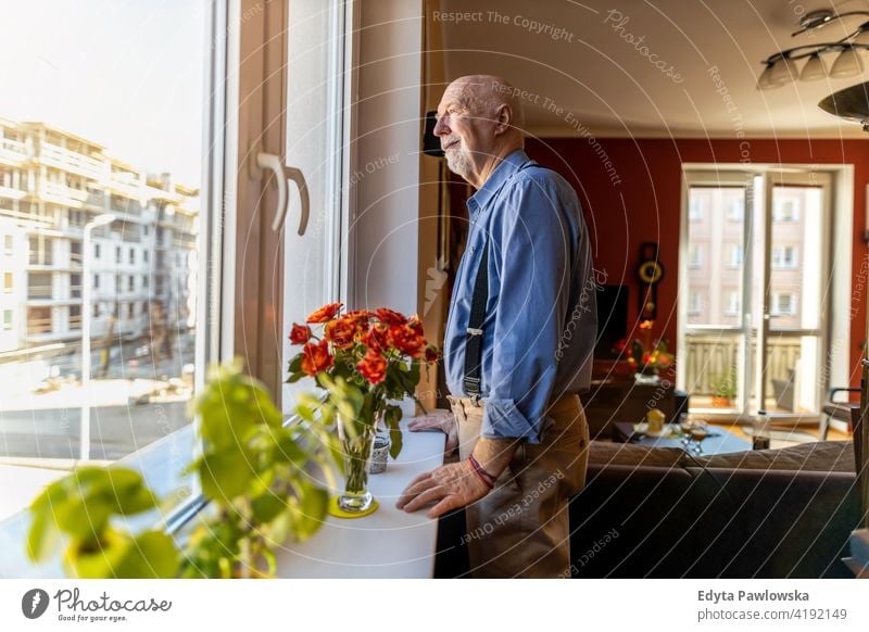 Senior Mann Blick durch Fenster zu Hause echte Menschen offen reif männlich Kaukasier älter heimwärts alt Alterung häusliches Leben Großvater Rentnerin