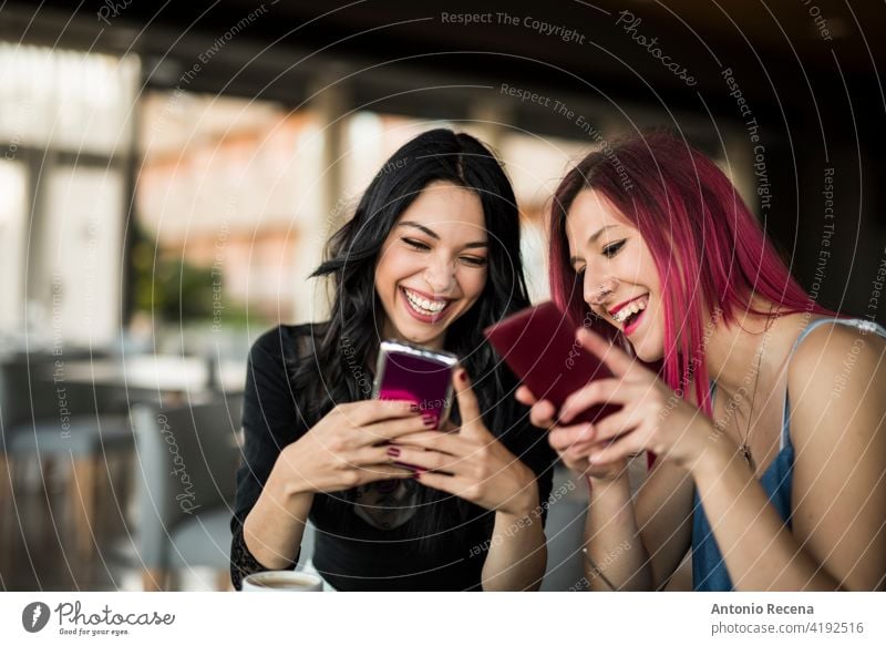 zwei hübsche Frauen suchen Telefone in Bar beim Trinken von Cola und Kaffee jung attraktiv 20s Freude Menschen Person Jugend urban Mitteilung Tablette