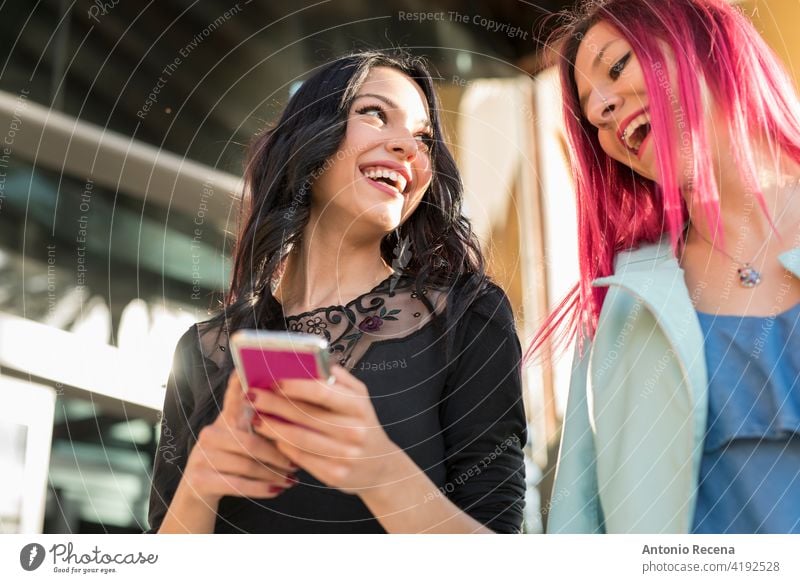 Lächelnde Frauen in der Stadt mit Smartphone lachend zusammen jung attraktiv 20s Freude Menschen Person Jugend urban hübsch hübsche Menschen im Freien Großstadt