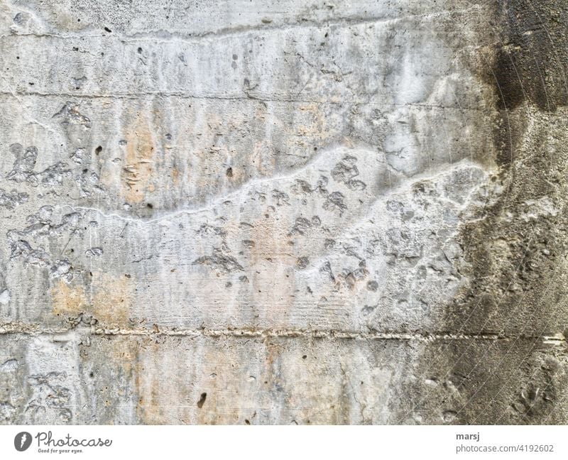 Muster und Strukturen, die an der Betonmauer durch Wasser und Witterung einfach so entstanden sind. Betonwand Fassade grau Mauer Bauwerk trist porös kalk
