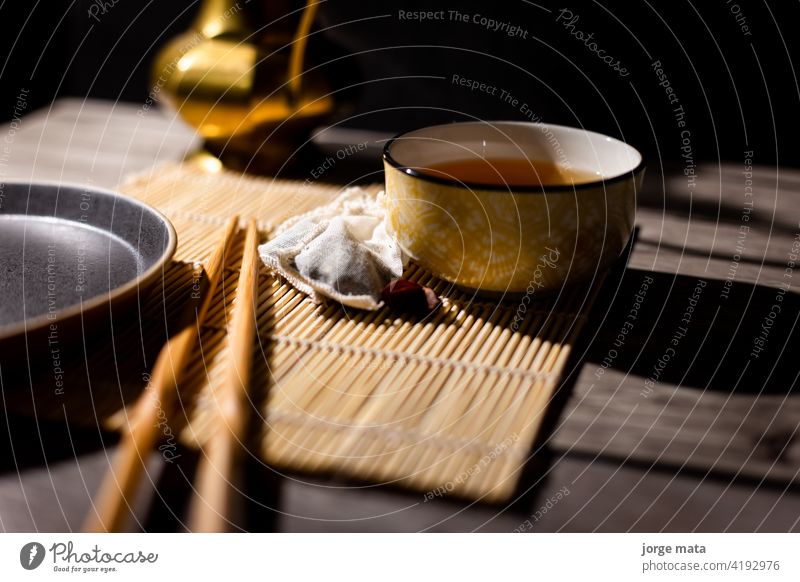 Dunkler Tee Hintergrund mit Tasse heißem Tee auf dem Tisch. chinesischer Tee China Medizin Tee - Heißgetränk Teezeremonie Teekocher