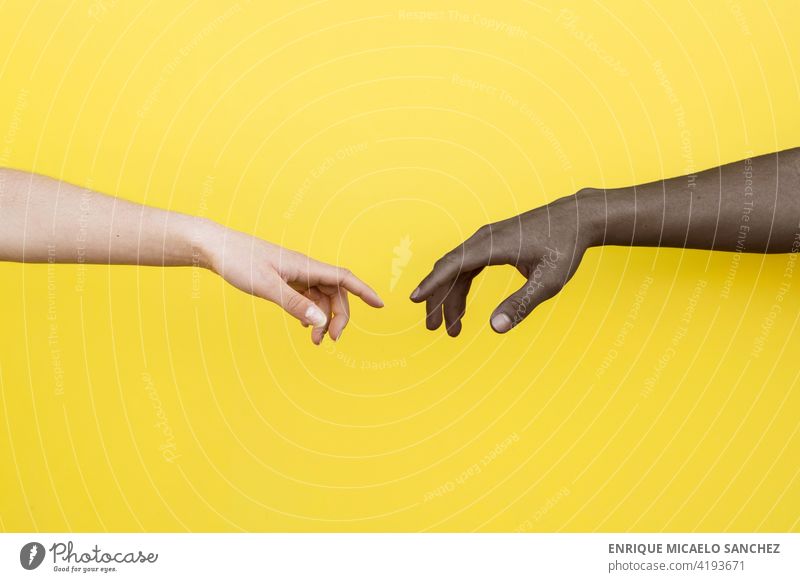 Weiße Hand und schwarze Hand über zu berühren auf gelbem Hintergrund Menschen Freundschaft Zusammensein umklammert Afrikanisch international Partnerschaft Haut