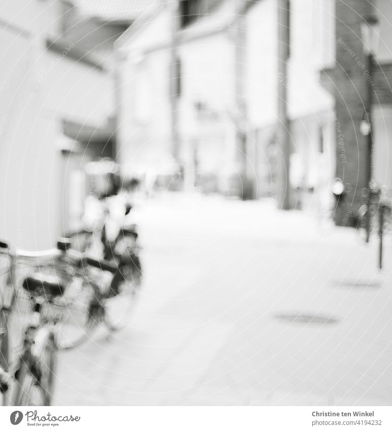 Leere Fußgängerzone in der Innenstadt mit abgestellten Fahrrädern. Schwarzweiß und unscharf. leer Menschenleer Gebäude Geschäfte Architektur Stadt Fassade