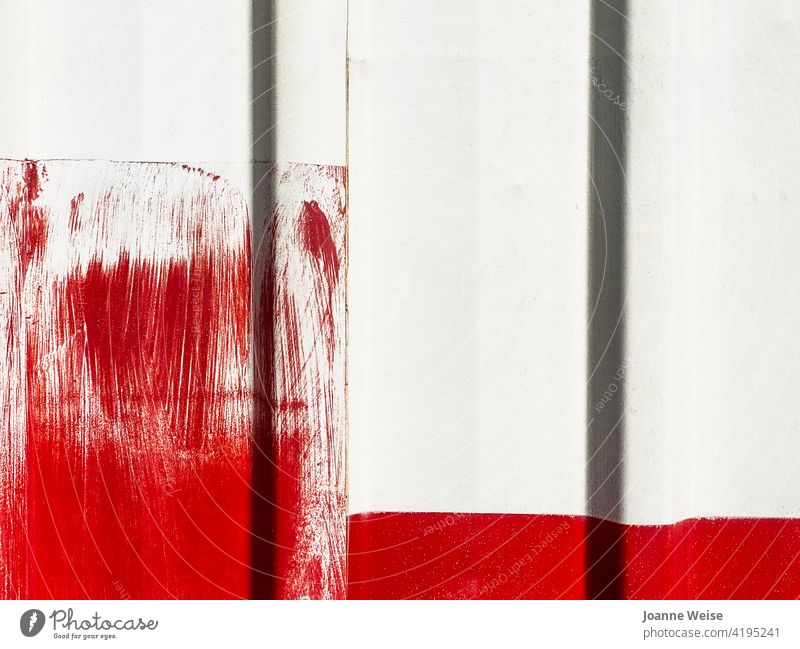 Weiße Wand mit leuchtend roten Farbpinselstrichen. weiße Wand rot und weiß rote Farbe Außenaufnahme Farbfoto Fassade Gebäude Tag Detailaufnahme Pinselstrich