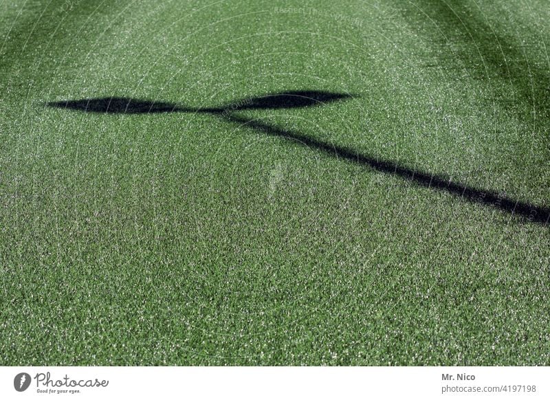 Schatten eines Flutlichtmast auf Kunstrasen Kunstrasenplatz grün Fußballplatz Sport Sportstätten Freizeit & Hobby Mast flutlichtmast Sportplatz Ballsport