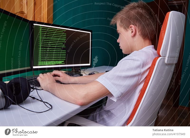 Ein junger Programmierer druckt den Programmcode auf dem Computerbildschirm aus. Das Konzept der Computersicherheit, Technologieentwicklung und junge Fachkräfte