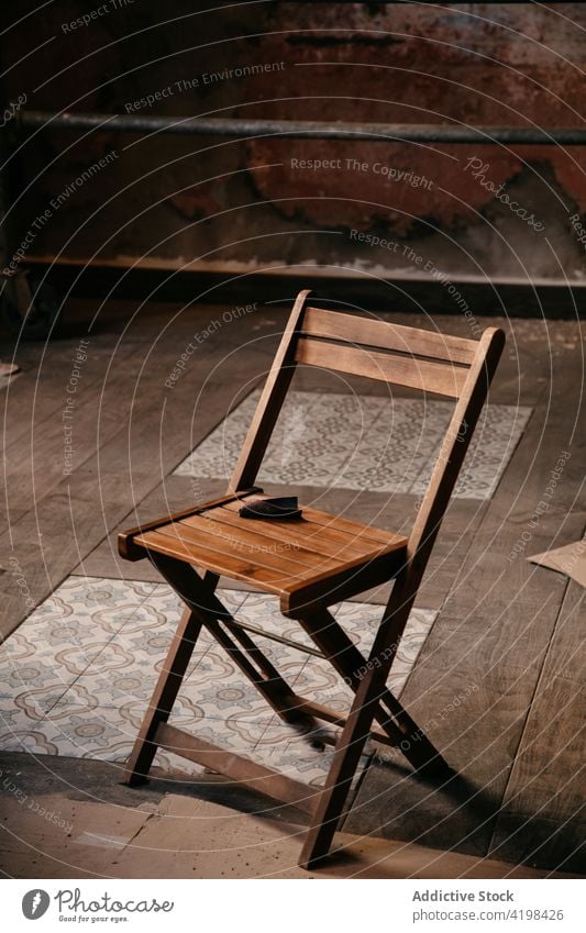 Holzschemel inmitten eines leeren Raums während der Renovierung Stuhl renovieren Reparatur staubig dreckig Erneuerung rekonstruieren Anwesen Verwesung Haus