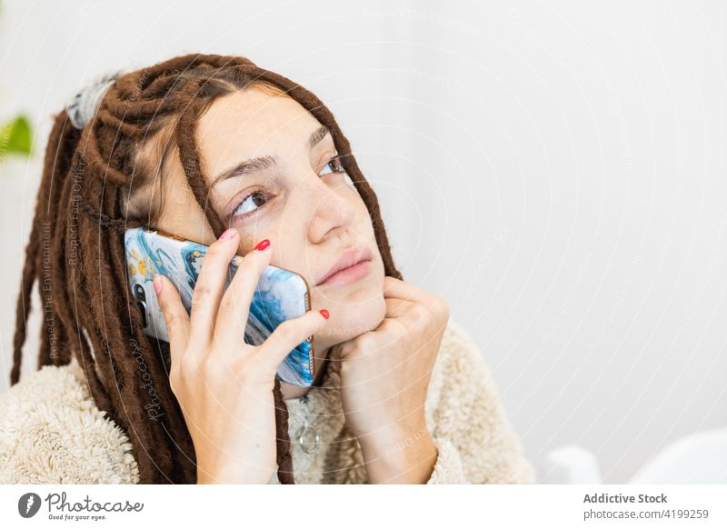Nahaufnahme einer Frau mit Zöpfen, die das Handy benutzt Funktelefon Telefon jung Mobile Zopf Rastalocken schön Menschen Porträt Person Technik & Technologie