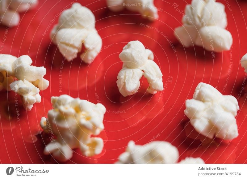 Nahaufnahme von Popcorn auf einem roten Hintergrund Draufsicht von oben Lebensmittel Popkorn Snack Mais lecker salzig roter Hintergrund weiß Salz geschmackvoll