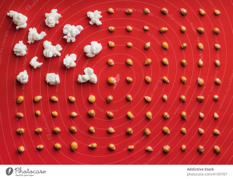 Nahaufnahme von Popcorn auf einem roten Hintergrund Draufsicht von oben Lebensmittel Popkorn Snack Mais lecker salzig roter Hintergrund weiß Salz geschmackvoll